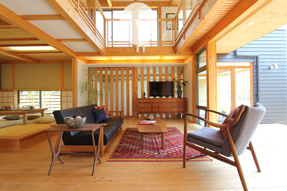 Foto di un soggiorno etnico aperto con sala formale, pareti bianche, pavimento in legno massello medio, TV autoportante e pavimento giallo