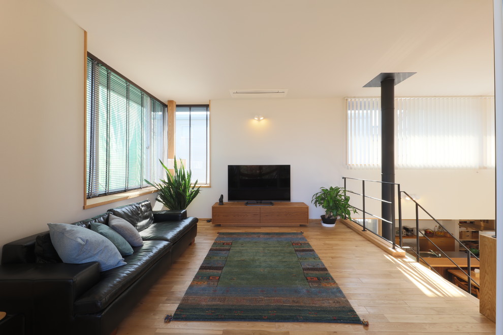 Nordisches Wohnzimmer mit weißer Wandfarbe, braunem Holzboden, beigem Boden, Kaminofen, Kaminumrandung aus Beton, Tapetendecke und Tapetenwänden in Sonstige