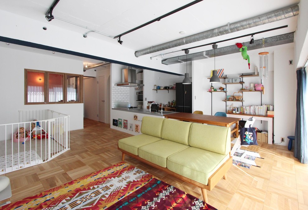 Cette image montre un salon urbain ouvert avec un mur blanc, un sol en bois brun et un sol marron.