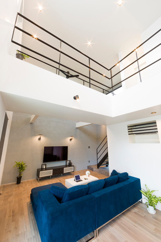 Offenes Modernes Wohnzimmer mit weißer Wandfarbe, hellem Holzboden und beigem Boden in Sonstige