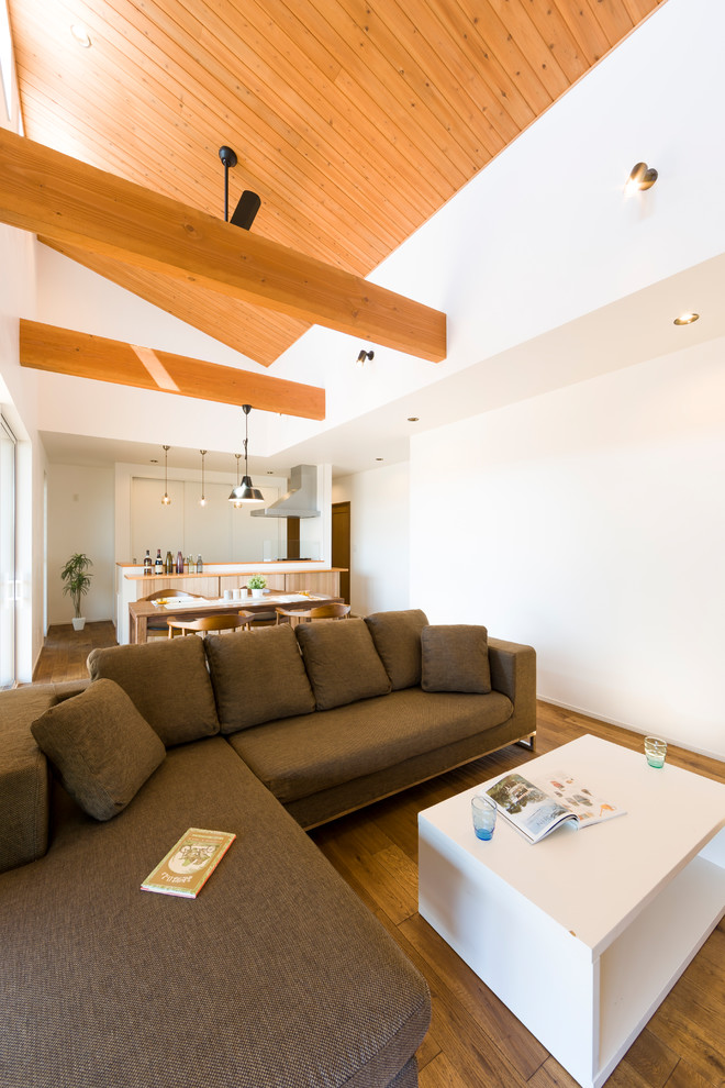 Immagine di un soggiorno moderno aperto con pareti bianche, pavimento in legno massello medio e pavimento marrone