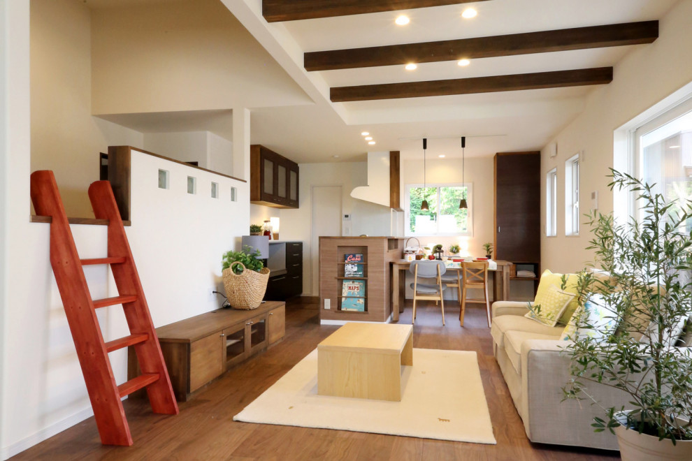 Foto på ett vardagsrum, med vita väggar, mörkt trägolv, en fristående TV och brunt golv