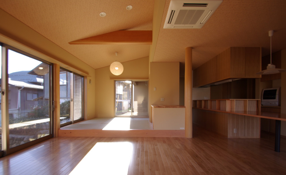 Mittelgroßes, Repräsentatives, Offenes Modernes Wohnzimmer ohne Kamin mit beiger Wandfarbe, braunem Holzboden und freistehendem TV in Sonstige