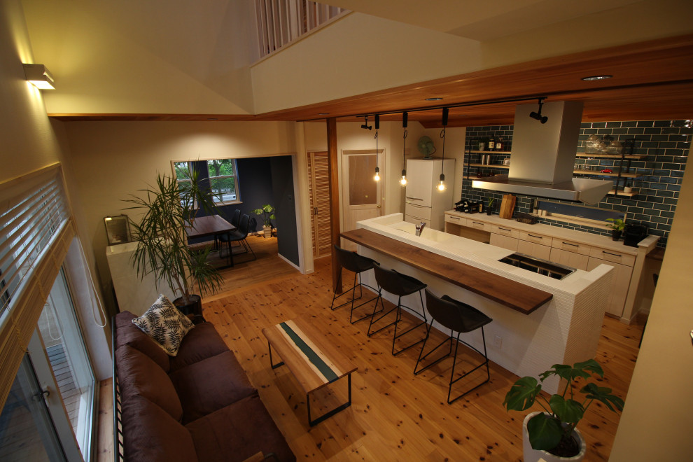 Foto de salón con barra de bar abierto de estilo zen pequeño con paredes azules, suelo de madera en tonos medios, televisor colgado en la pared, suelo marrón, madera y papel pintado