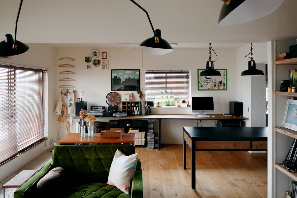 Cette photo montre un salon industriel avec un mur blanc, un sol en bois brun, un sol marron et un téléviseur indépendant.