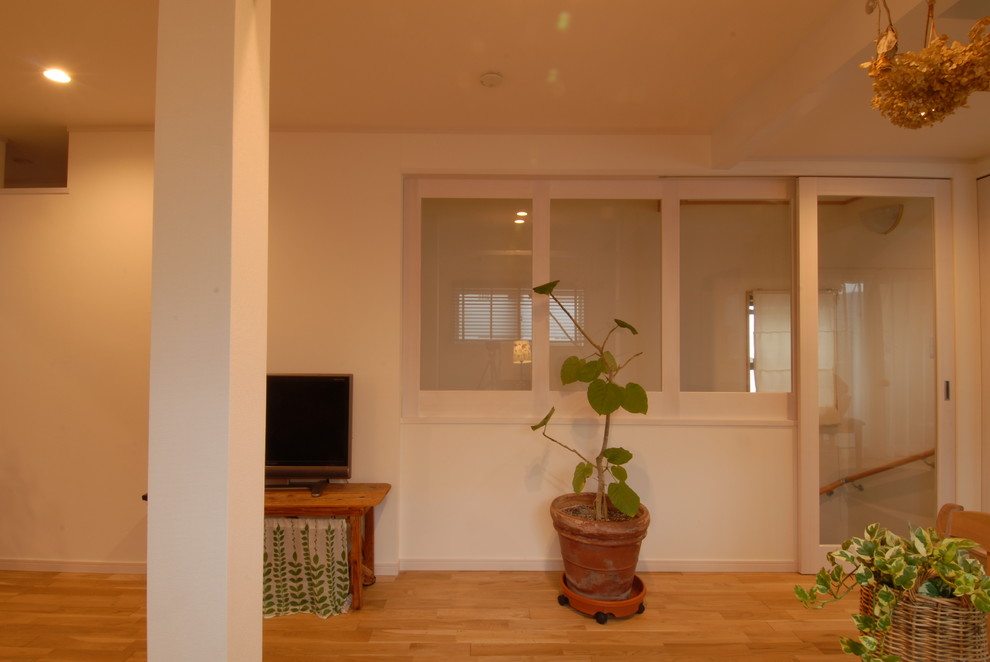 This is an example of a contemporary open plan living room in Yokohama with white walls and medium hardwood flooring.