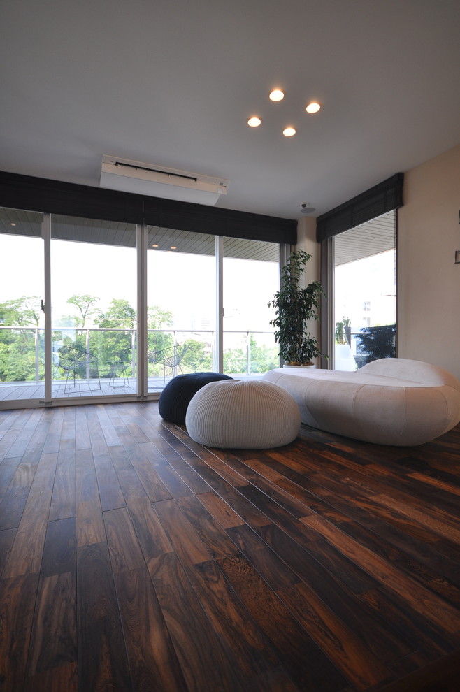 Fernseherloses Modernes Wohnzimmer ohne Kamin mit weißer Wandfarbe, dunklem Holzboden und schwarzem Boden in Sonstige
