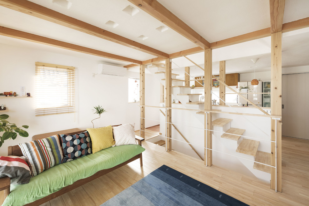 Offenes Asiatisches Wohnzimmer mit weißer Wandfarbe, hellem Holzboden und beigem Boden in Sonstige
