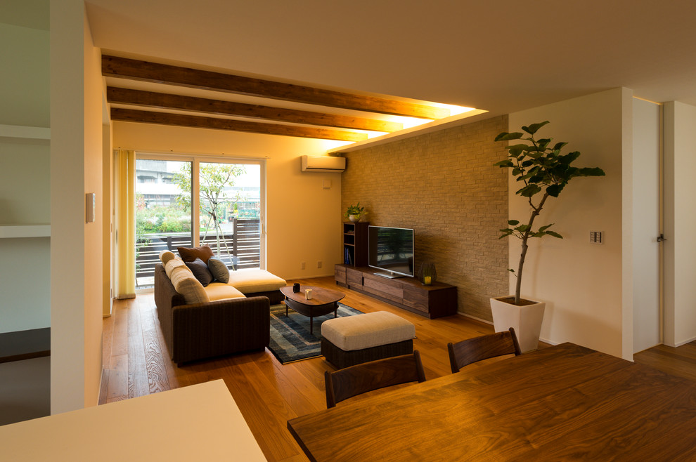 Imagen de salón asiático con paredes multicolor, suelo de madera en tonos medios, televisor independiente y suelo marrón