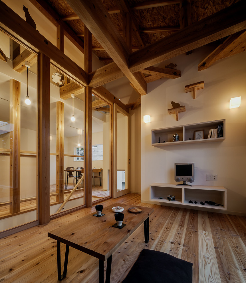 Immagine di un soggiorno chiuso con pareti bianche, pavimento in legno massello medio e pavimento marrone