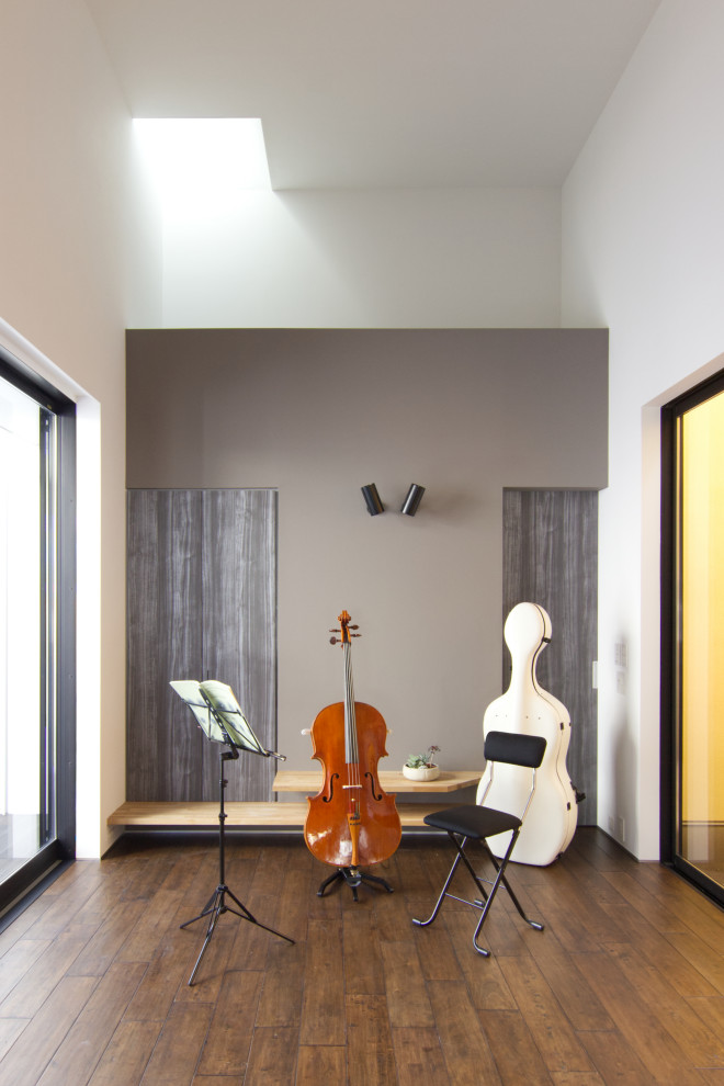 Ejemplo de salón con rincón musical abierto minimalista con paredes blancas, suelo de madera oscura y suelo marrón