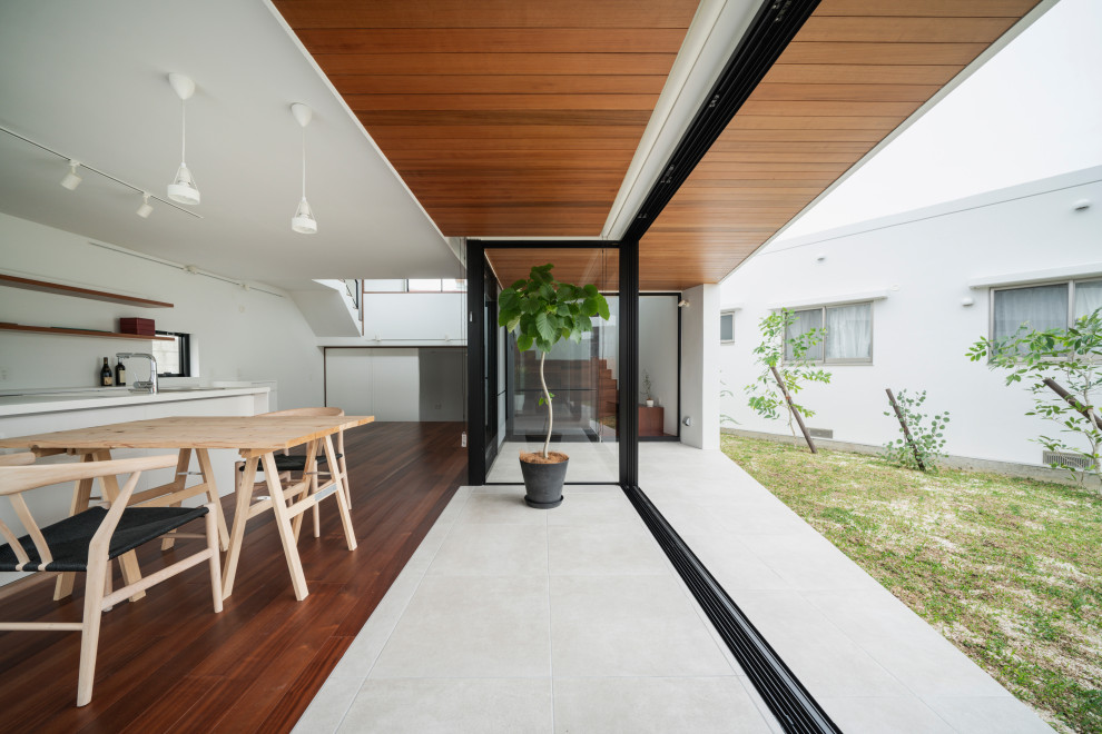 Offenes Modernes Wohnzimmer mit weißer Wandfarbe, dunklem Holzboden und Holzdecke in Sonstige