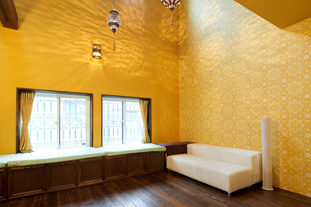 Foto di un soggiorno rustico di medie dimensioni e aperto con angolo bar, pareti gialle, parquet scuro, pavimento marrone, travi a vista e carta da parati