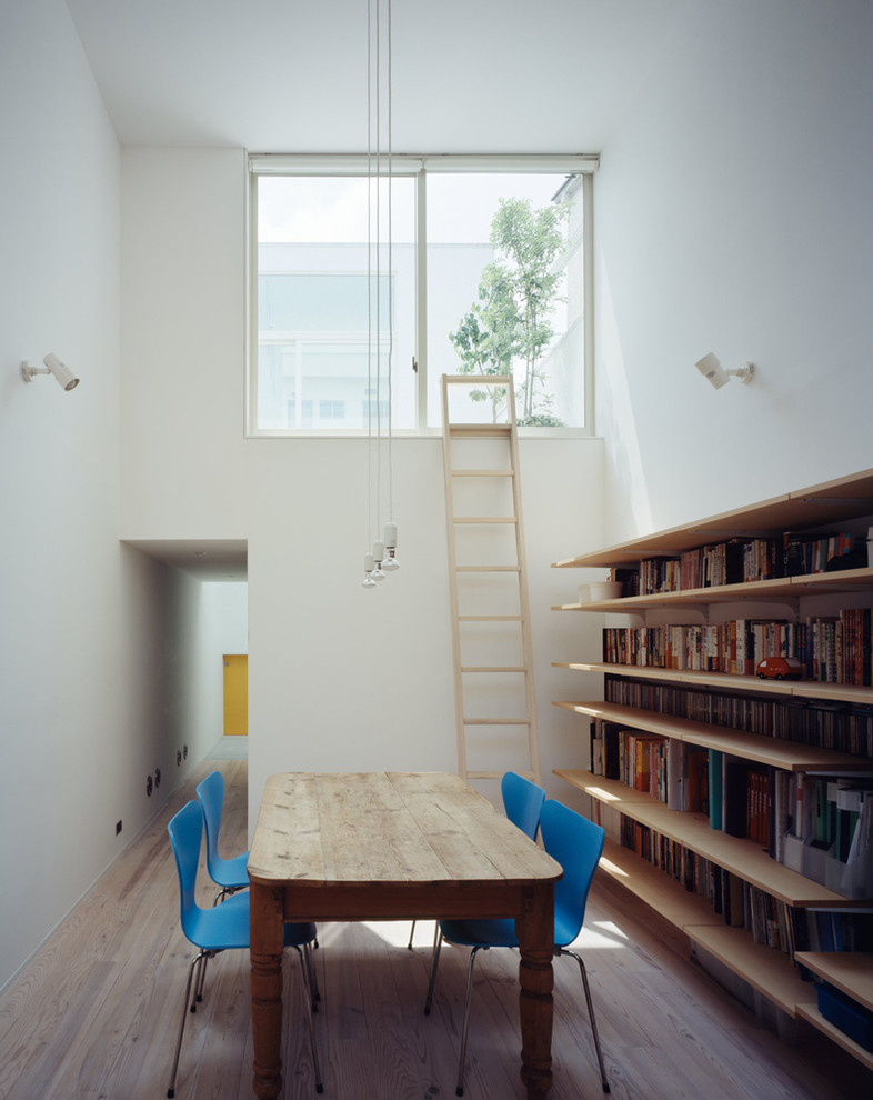 Foto di un soggiorno minimalista di medie dimensioni e aperto con pareti bianche, parquet chiaro, nessun camino, libreria, TV autoportante e pavimento beige