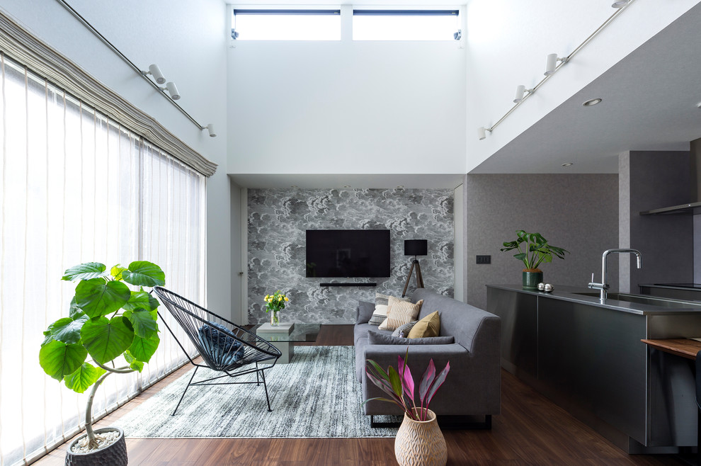 Repräsentatives, Offenes Asiatisches Wohnzimmer mit weißer Wandfarbe, dunklem Holzboden, TV-Wand und braunem Boden in Sonstige