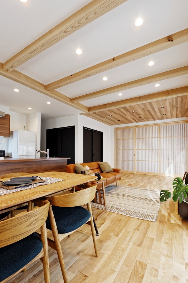 Foto di un soggiorno minimalista aperto con sala formale, pareti bianche, parquet chiaro e pavimento arancione