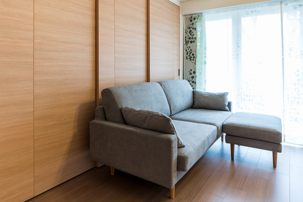 Immagine di un soggiorno etnico di medie dimensioni con pareti bianche, pavimento in compensato, nessun camino, TV autoportante e pavimento beige