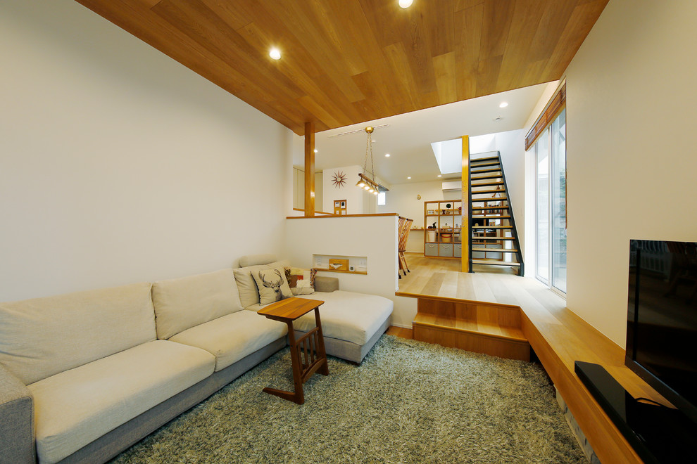 Ispirazione per un soggiorno scandinavo di medie dimensioni e aperto con sala formale, pareti bianche, pavimento in legno massello medio, TV autoportante e pavimento marrone