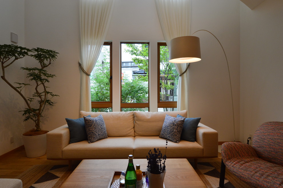 Foto di un grande soggiorno moderno aperto con pareti arancioni, pavimento in legno massello medio, nessun camino e TV autoportante