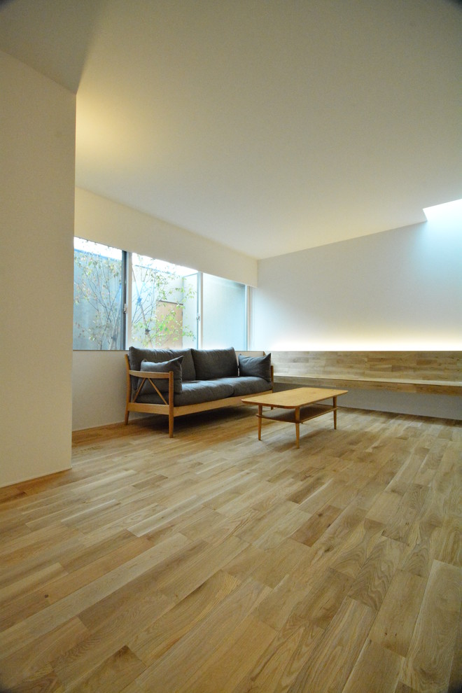 Idee per un soggiorno nordico aperto con pareti bianche, pavimento in legno massello medio, nessun camino e pavimento beige