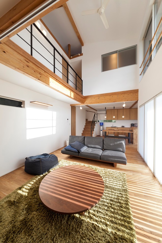 Diseño de salón de estilo zen con paredes blancas y suelo marrón