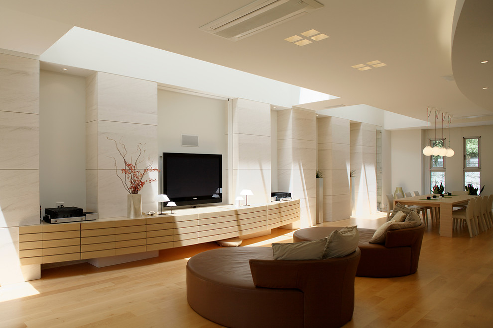 Idée de décoration pour un salon design avec un mur blanc, un sol en bois brun, un téléviseur indépendant et un sol marron.