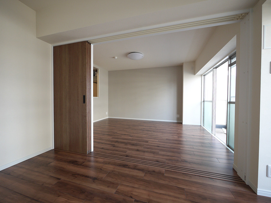 This is an example of a modern open plan living room in Tokyo with grey walls, plywood flooring and brown floors.