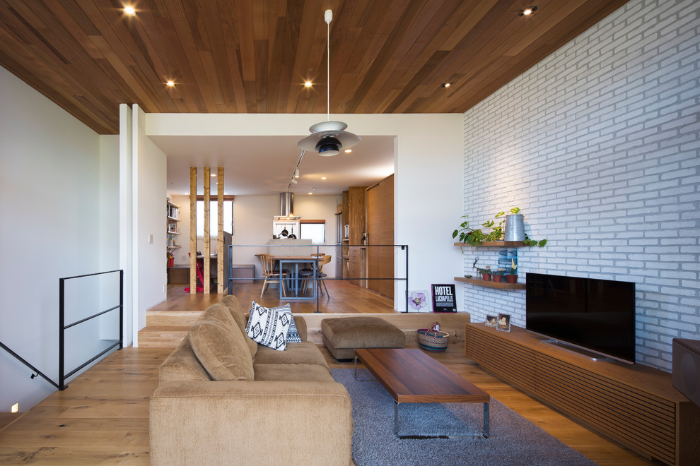 Modernes Wohnzimmer ohne Kamin mit weißer Wandfarbe, braunem Holzboden und freistehendem TV in Tokio