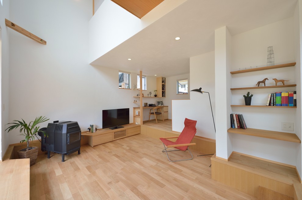 Nordisches Wohnzimmer mit weißer Wandfarbe, hellem Holzboden und beigem Boden in Sonstige