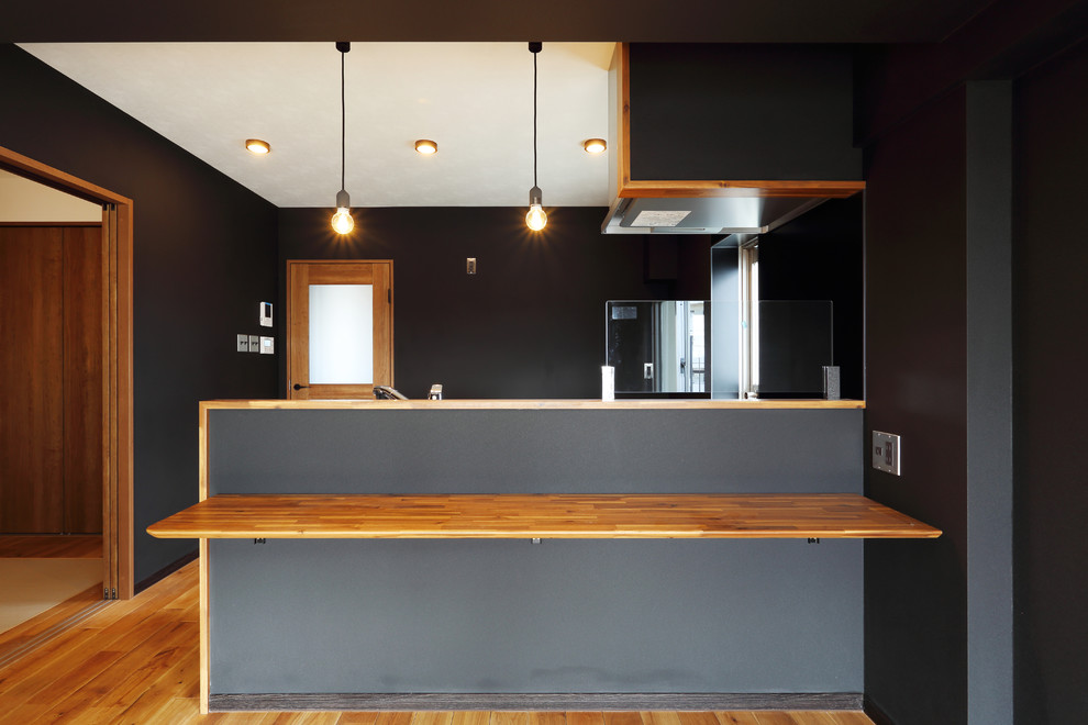 Aménagement d'un salon moderne de taille moyenne et ouvert avec un mur noir, un sol en bois brun et un sol marron.