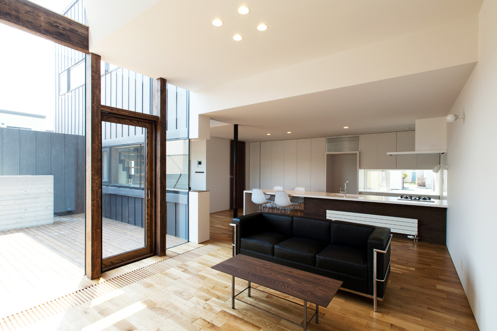 Idées déco pour un salon moderne avec un mur blanc, un sol en bois brun et un sol marron.
