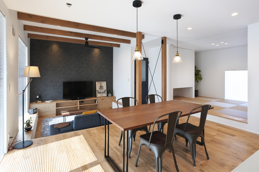 Imagen de salón abierto urbano grande con paredes blancas, suelo de madera clara, televisor independiente y suelo marrón