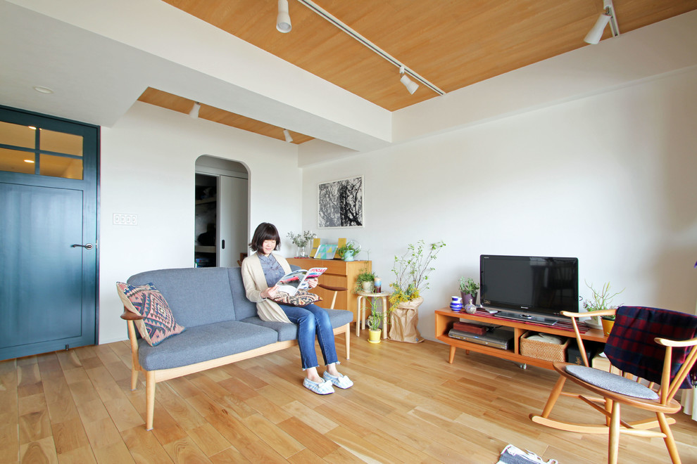 Diseño de salón abierto nórdico con paredes blancas, suelo de madera en tonos medios y suelo beige