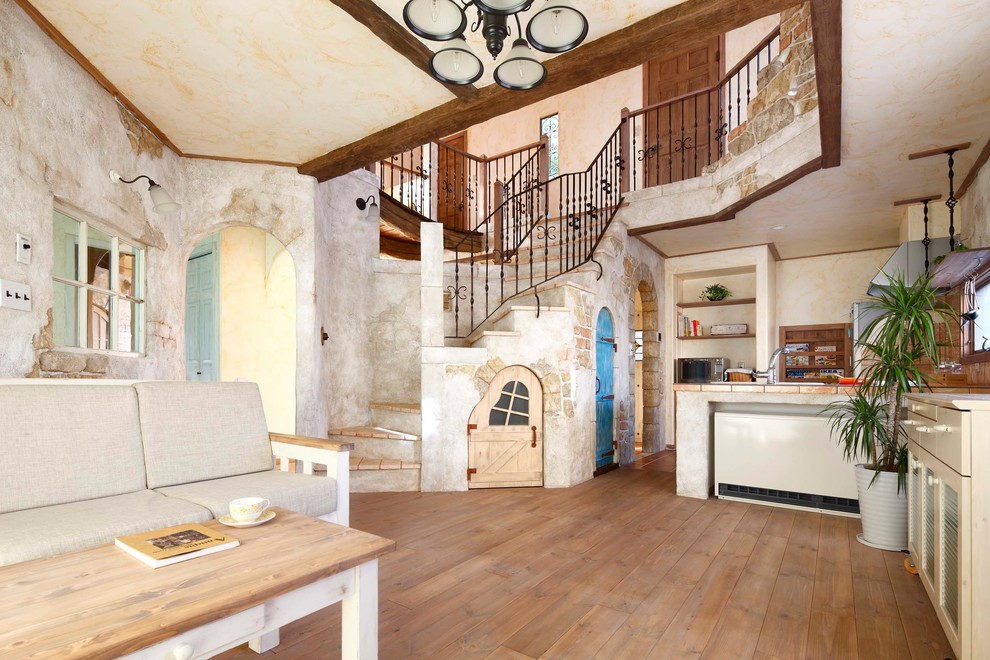 Idee per un soggiorno mediterraneo aperto con pareti beige, pavimento in legno massello medio e pavimento marrone