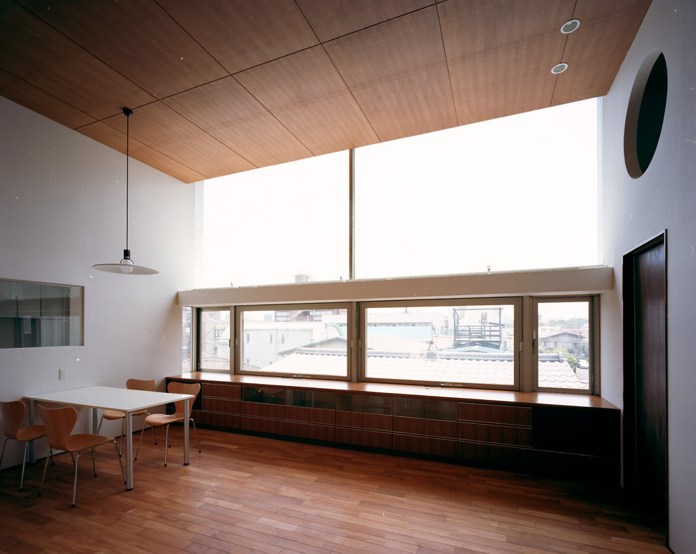 Idéer för ett stort modernt allrum med öppen planlösning, med en hemmabar, vita väggar, mellanmörkt trägolv, en spiselkrans i gips, en fristående TV och brunt golv