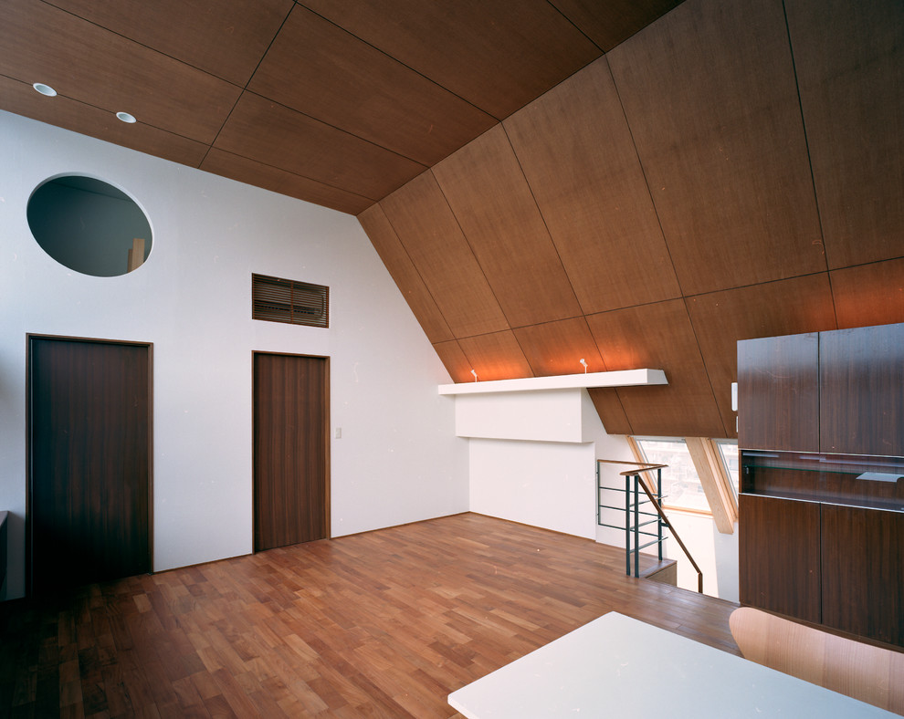 Großes, Offenes Asiatisches Wohnzimmer ohne Kamin mit Hausbar, weißer Wandfarbe, braunem Holzboden, verputzter Kaminumrandung, freistehendem TV und braunem Boden in Tokio