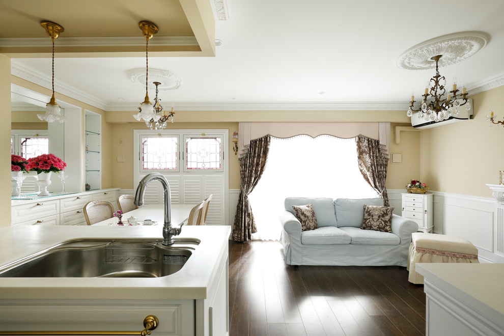 Idée de décoration pour un salon tradition de taille moyenne et ouvert avec un mur beige, parquet foncé et un sol marron.