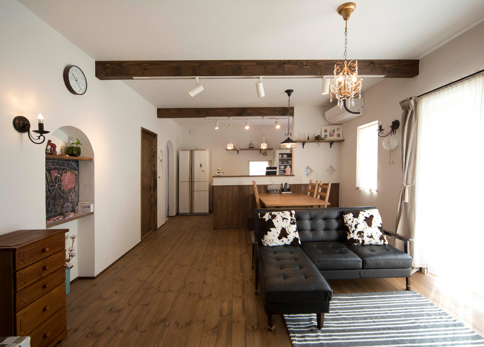 Modelo de salón abierto de estilo de casa de campo con paredes blancas, suelo de madera oscura y suelo marrón