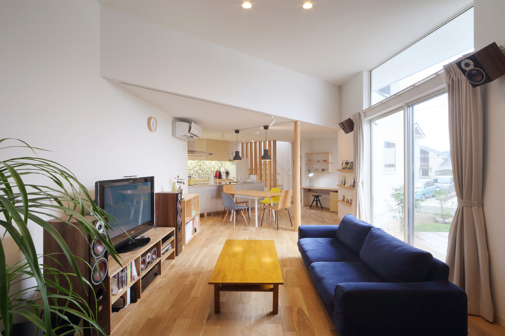 Asiatisches Wohnzimmer ohne Kamin mit weißer Wandfarbe, braunem Holzboden, freistehendem TV und braunem Boden in Yokohama