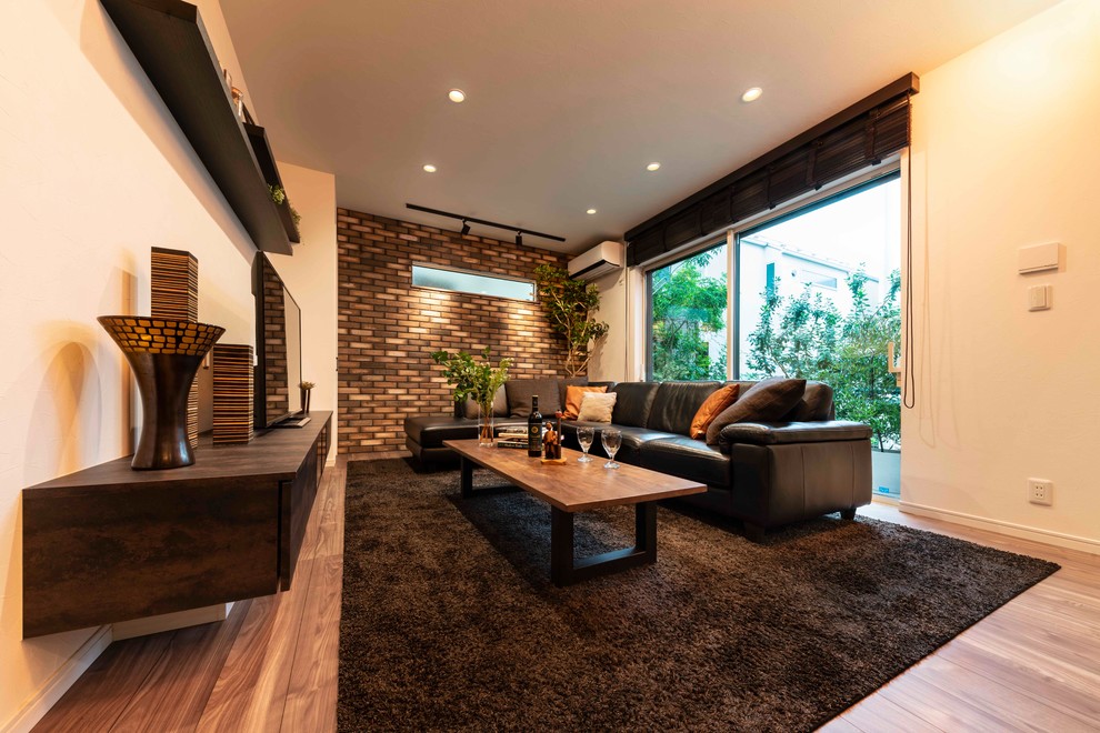 Medium sized modern formal open plan living room in Tokyo with brown walls, plywood flooring, a two-sided fireplace, a wooden fireplace surround, a freestanding tv and brown floors.
