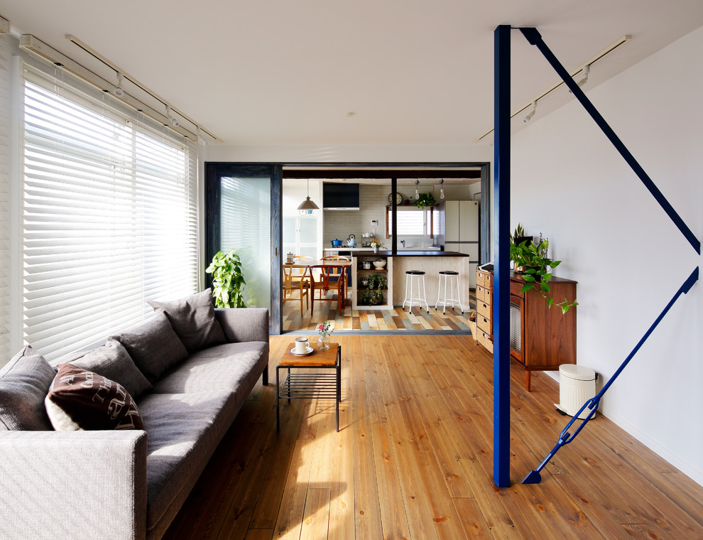 Idee per un soggiorno scandinavo aperto con pareti bianche, pavimento in legno massello medio e pavimento marrone