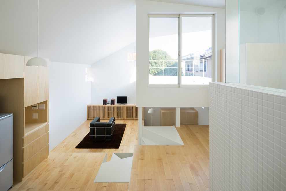 Modelo de salón abierto moderno pequeño con paredes blancas, suelo de madera en tonos medios y televisor independiente