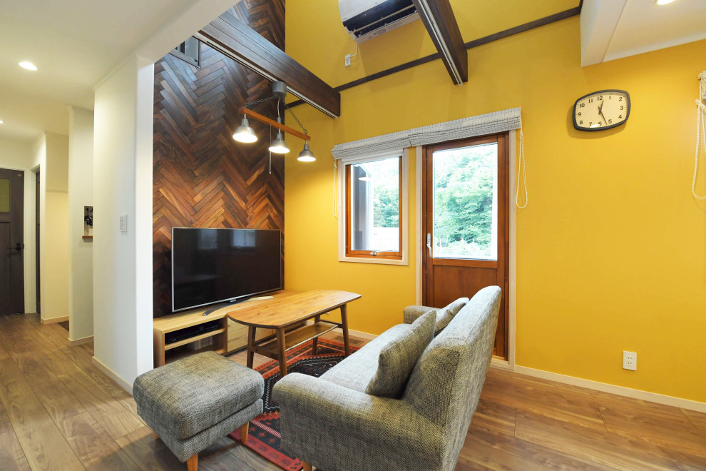 Aménagement d'un grand salon scandinave ouvert avec un mur multicolore, aucune cheminée, un téléviseur indépendant et un sol beige.