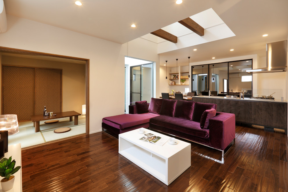 Immagine di un soggiorno etnico aperto con pareti bianche, parquet scuro e pavimento marrone