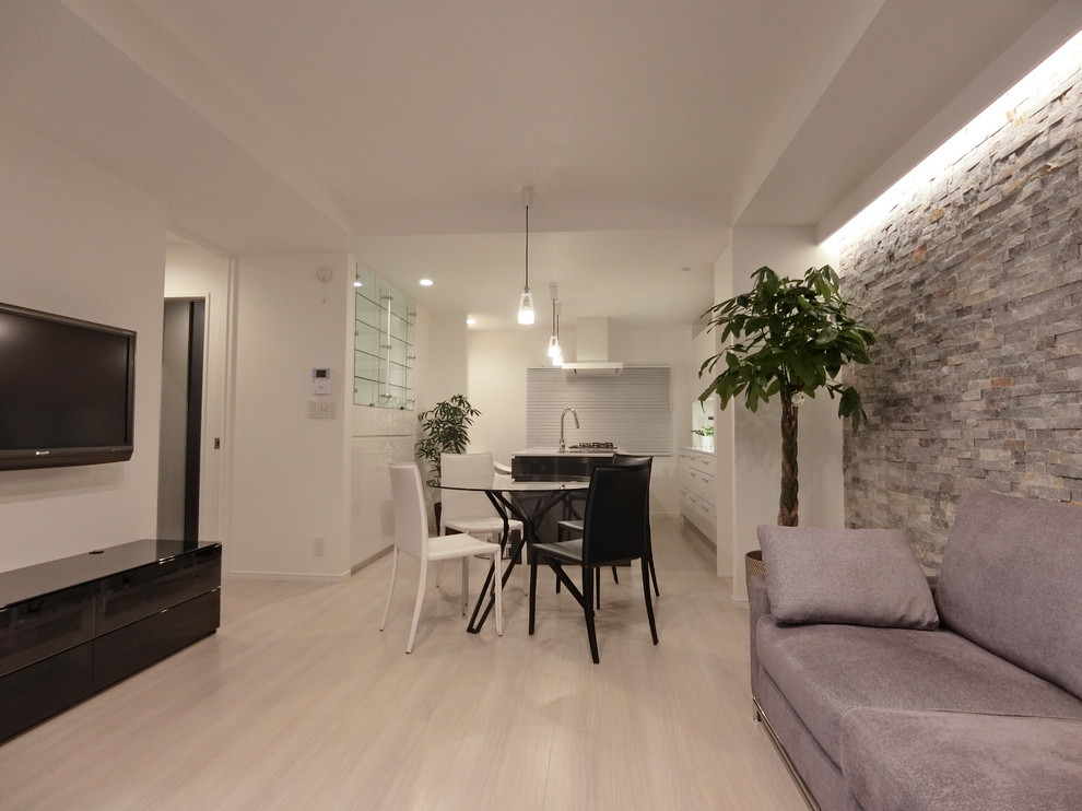 Réalisation d'un salon minimaliste de taille moyenne et ouvert avec un mur blanc, parquet clair, un téléviseur fixé au mur et un sol blanc.