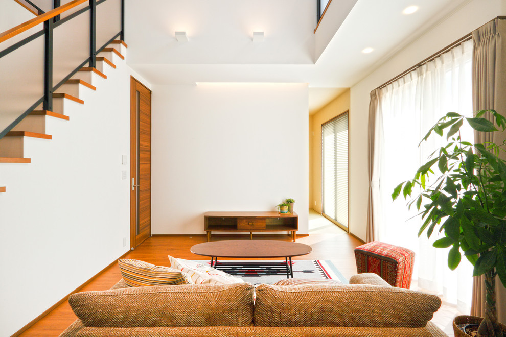 Diseño de salón asiático con suelo de madera en tonos medios y suelo marrón