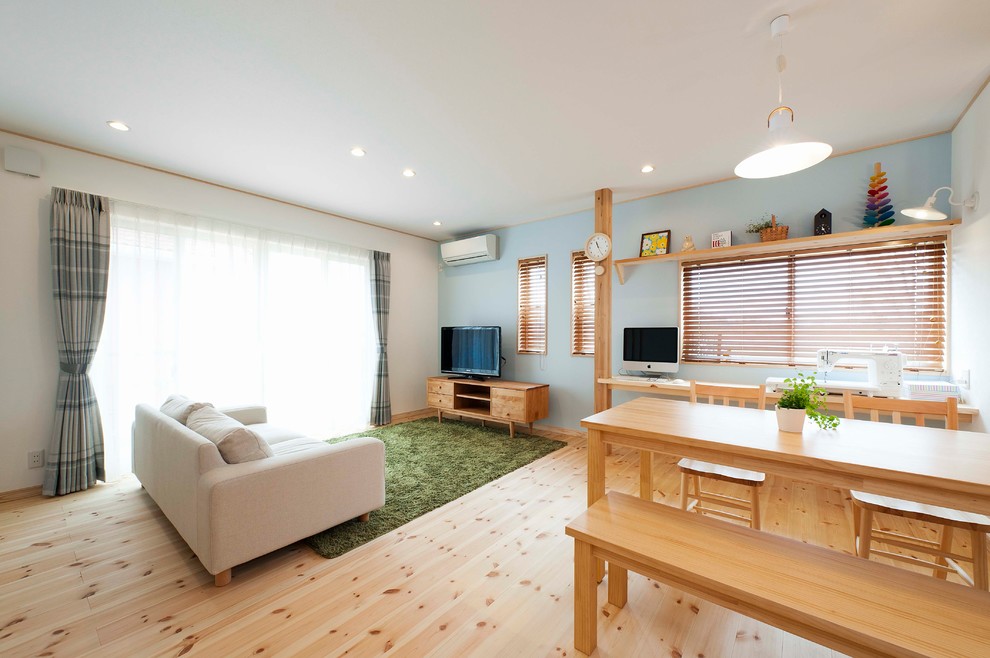 На фото: гостиная комната в восточном стиле с синими стенами, светлым паркетным полом и коричневым полом