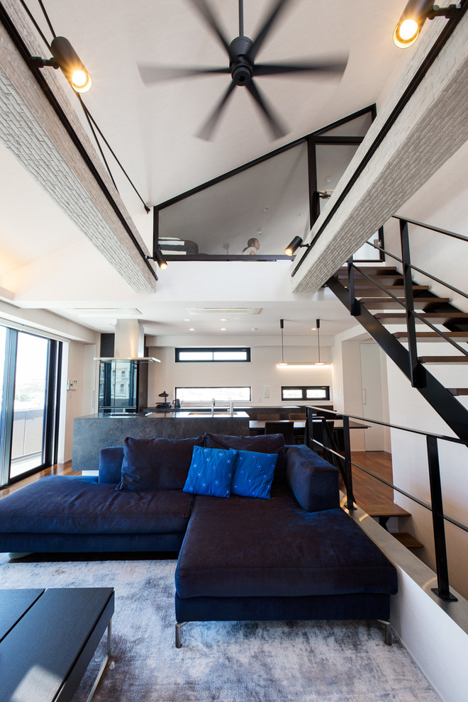 Ispirazione per un soggiorno moderno aperto con pareti bianche, pavimento in legno massello medio, pavimento marrone e tappeto