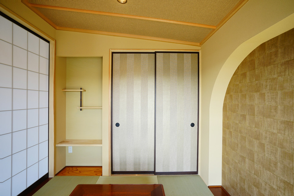 На фото: изолированная гостиная комната среднего размера в восточном стиле с татами, бежевыми стенами и зеленым полом без телевизора