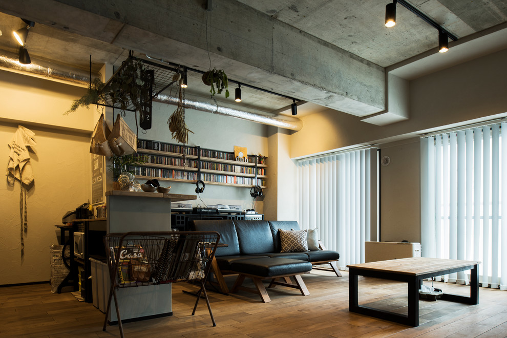 Immagine di un soggiorno industriale aperto con pareti bianche, pavimento in legno massello medio e pavimento marrone